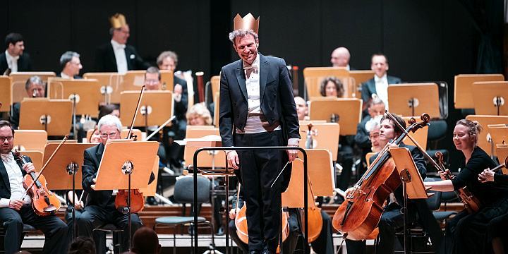 JenaerPhilharmonie mit GMD Simon Gaudenz, der ins Publikum schaut und eine Krone trägt  ©JenaKultur, C. Worsch