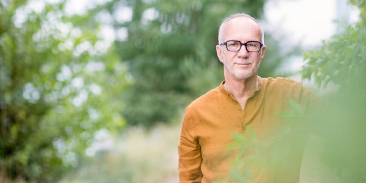 Schriftsteller Daniel Glattauer auf einer Wiese zwischen Bäumen und Büschen