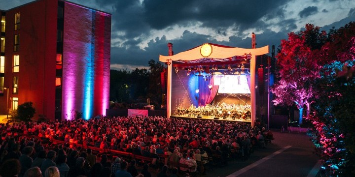 ArenaOuvertüre am Abend: Publikum mit Blick auf Bühne, beleuchtete Bäume und Wohnblock  ©JenaKultur, C. Worsch