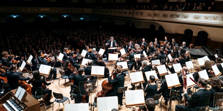 Musiker der Jenaer Philharmonie mit GMD Gaudenz im Volkshaus und Publikum im Hintergrund  ©JenaKultur, C. Worsch
