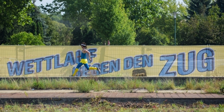 Blick aus dem Zug auf einen Fahrradfahrer auf einem Acker