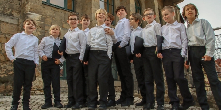 Jungen des Jenaer Knabenchor in weißen Hemden und schwarzen Hosen, mit Notenmappen unter den Arm geklemmt stehen locker am Normannenhaus Jena zusammen