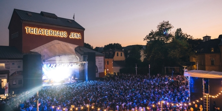 Publikum vor der erleuchteten Bühne der Kulturarena Jena