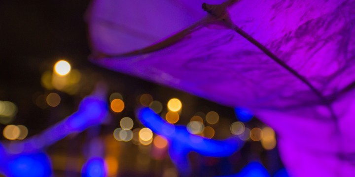 Violett beleuchtete Papierlaterne und Lichterglanz im Hintegrrund