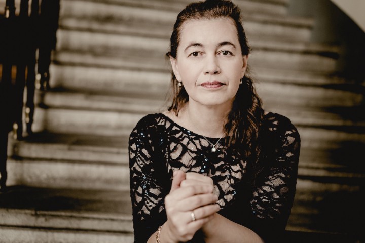 Pianistin Lilya Zilberstein im schwarzen Spitzenkleid auf einer Treppe sitzend