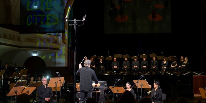 Manifesto Uraufführung mit GMD Simon Gaudenz, Orchester und Chor auf der Bühne im Volkshaus Jena