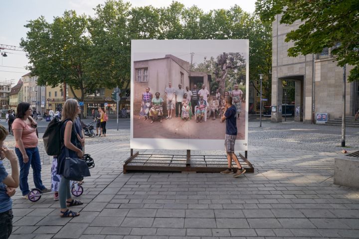 Foto einer Stadtführung zu den Plakaten der Reihe "Völkerfreundschaft mit Mosambik" am Holzmarkt in Jena