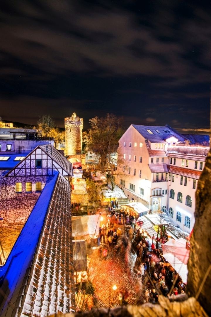 Das Stadtmauerensemble und buntes Treiben auf dem Weihnachtsmarkt in festlicher Beleuchtung