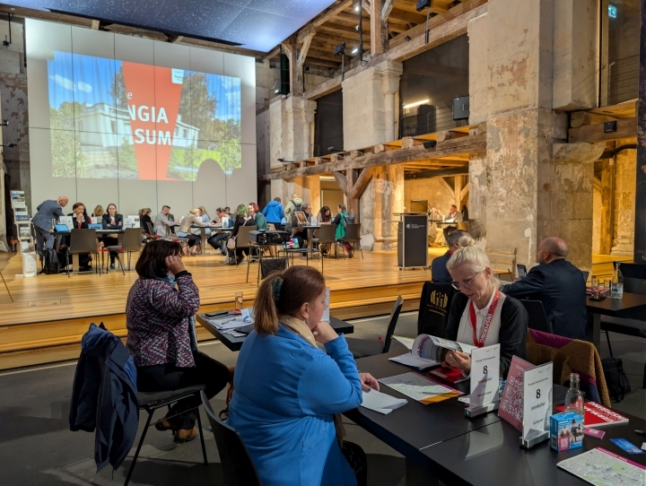 Teilnehmende der Travel Summit sitzen an Tischen zusammen