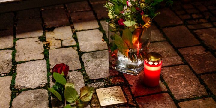 Stolperstein mit Rosen bei Nacht 