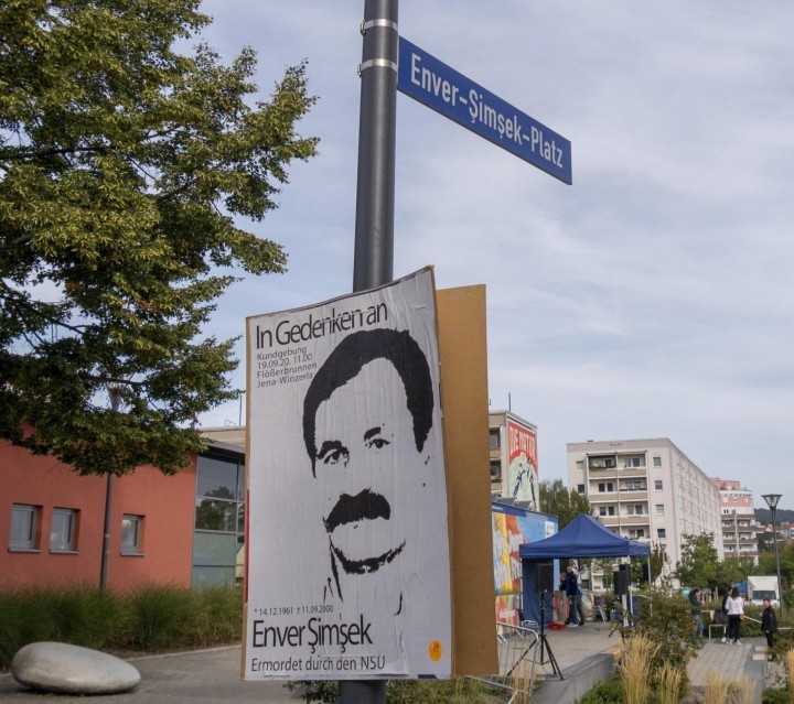 Straßenschild des neuen Enver-Simsek-Platzes in Jena mit einem Plakat mit Aufruf zum Gedenken
