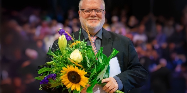 Alexander Richter hält bei einer Preisverleihung einen Blumenstrauß in Händen  &copy;Julian Thiemermann