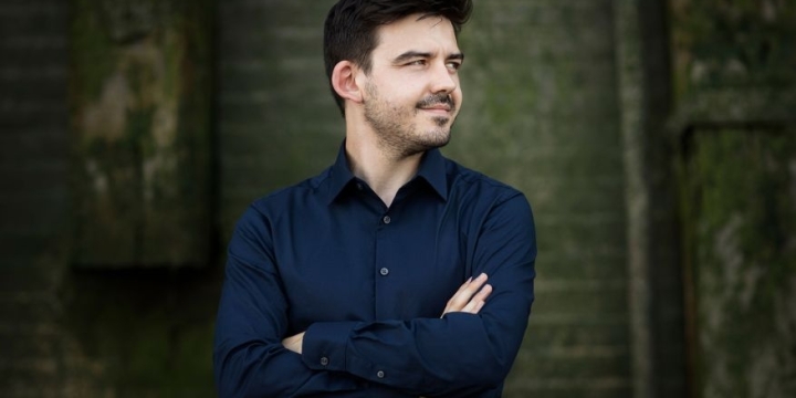 Harry Ogg posiert mit eingeschränkten Armen vor einer Mauer