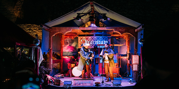 Zwei mittelalterlich gewandete Musiker auf einer beleuchteten Bühne spielen Dudelsack.  ©JenaKultur, C. Worsch