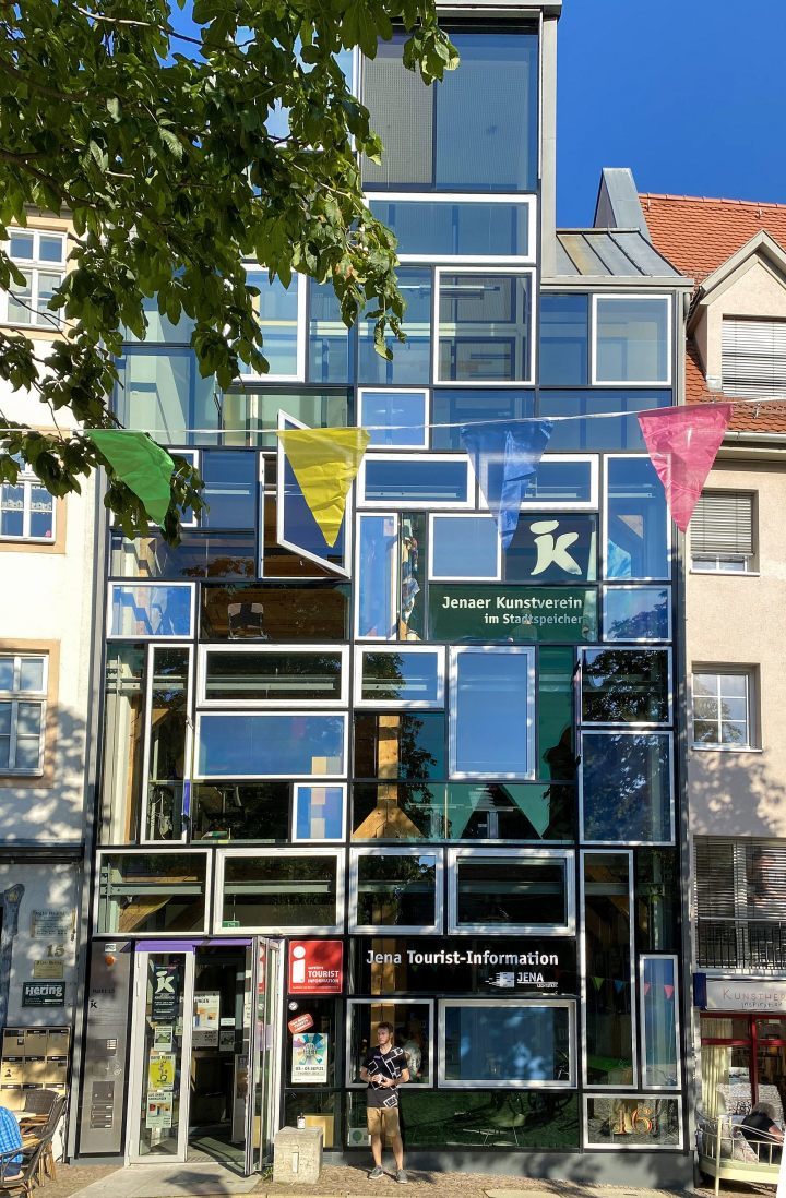 Jena Tourist-Information, Außenansicht, davor hängen bunte Wimpel