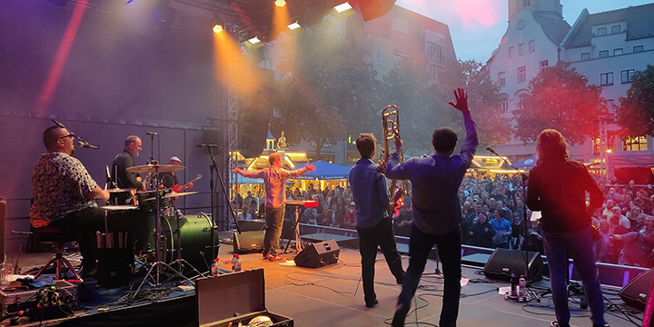 Blick von der Bühne ins Publikum: Bandmitgleider von Babayaga stehen auf der Bühne des Jenaer Frühlingsmarktes und performen, 