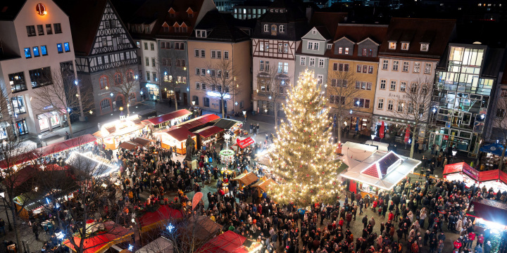 Blick von oben auf den Markt mit beleuchtetem Jenaer Weihnachtsmarkt und vielen Gästen.  ©JenaKultur, C. Worsch