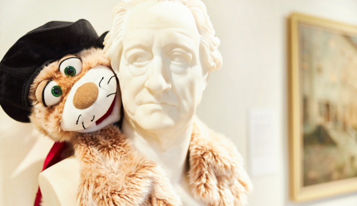 Maskottchen des Romantikerhauses, eine Katze hängt an einer Büste von Goethe