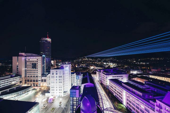 Blick auf das nächtliche Jena, Laser erhellen den Himmel zur LNDW Jena