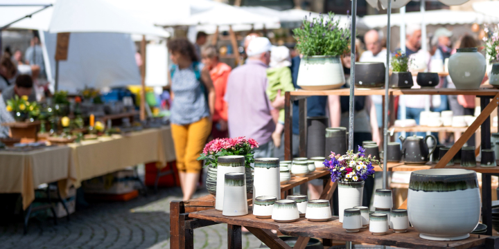 Gäste des Jenaer Töpfermarktes passieren Stände mit unzähligen Keramiken auf dem historischen Marktplatz Jena