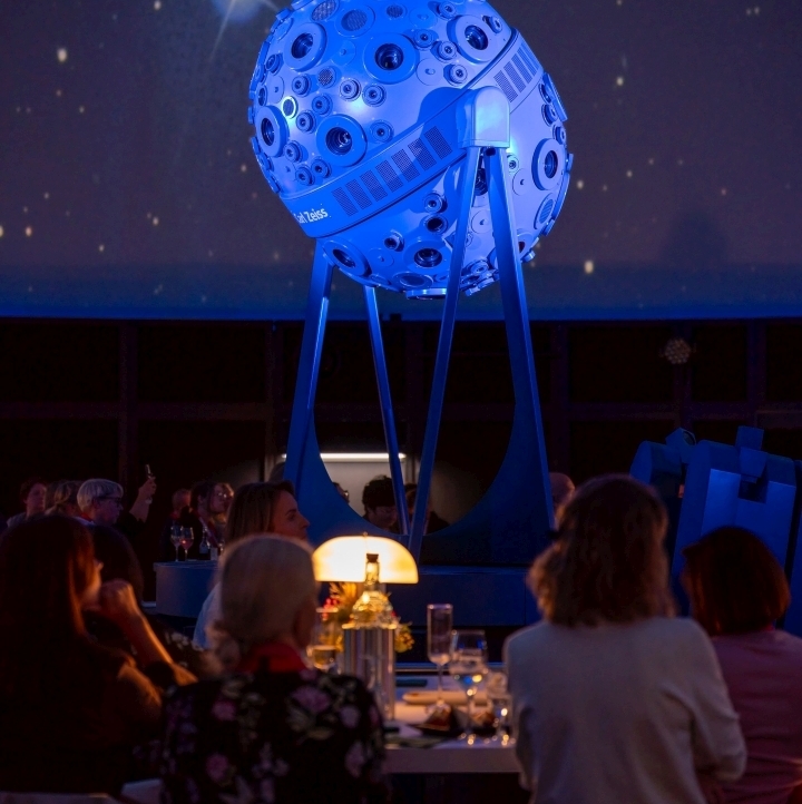 Besucher:innen des Travel Summit sitzen im Planetarium Jena