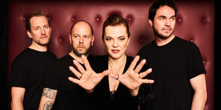 Portrait der Band Die Happy mit der Frontfrau im Mittelpunkt und kräftigen Farben