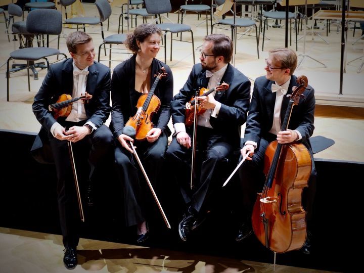 Musiker:innen des tauber quartetts der Jenaer Philharmonie mit ihren Instrumenten auf der Bühne sitzend